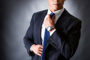ネクタイを直すスーツの男性